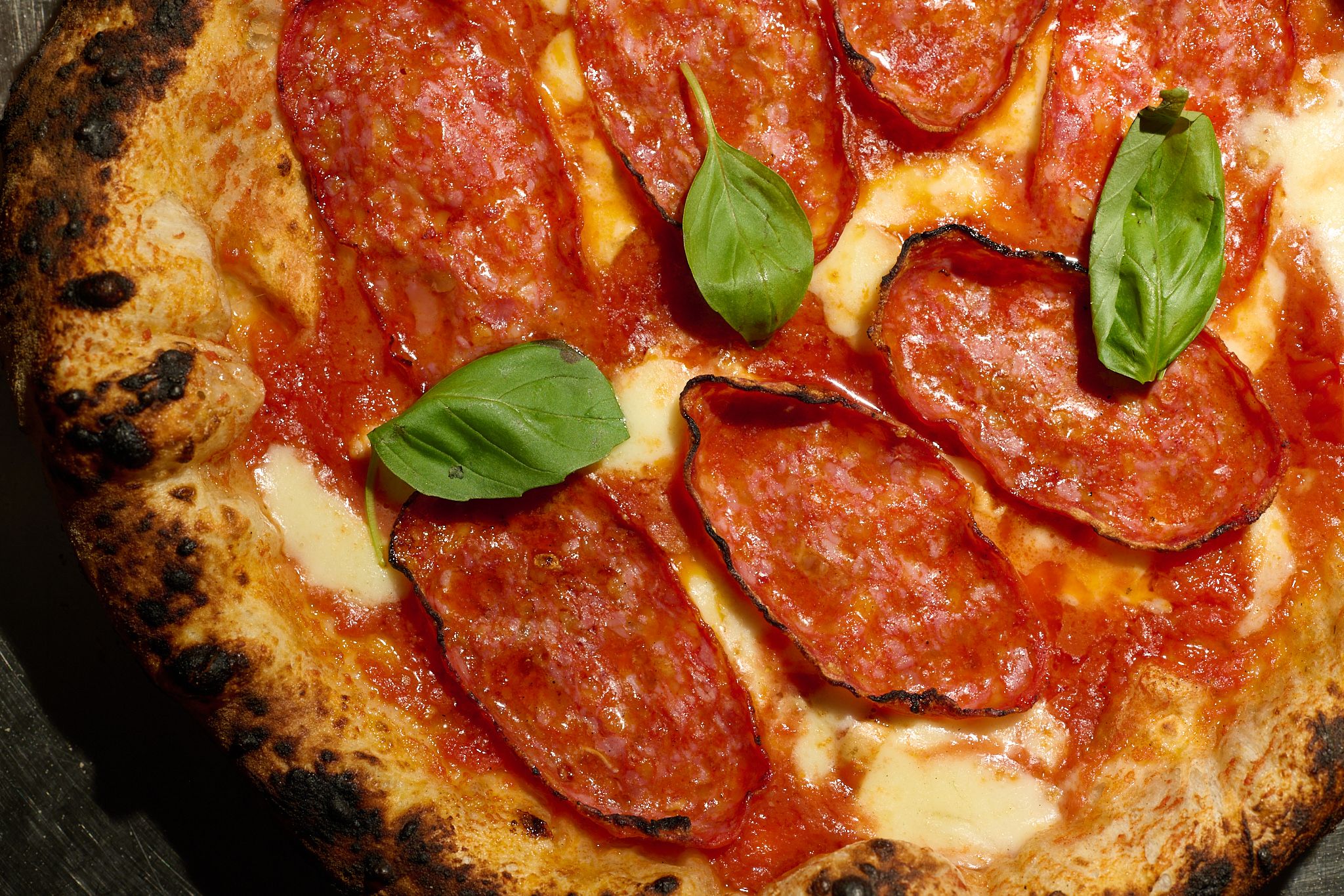 Pizza Diavola con spianata piccante, fior di latte e basilico, da vicino