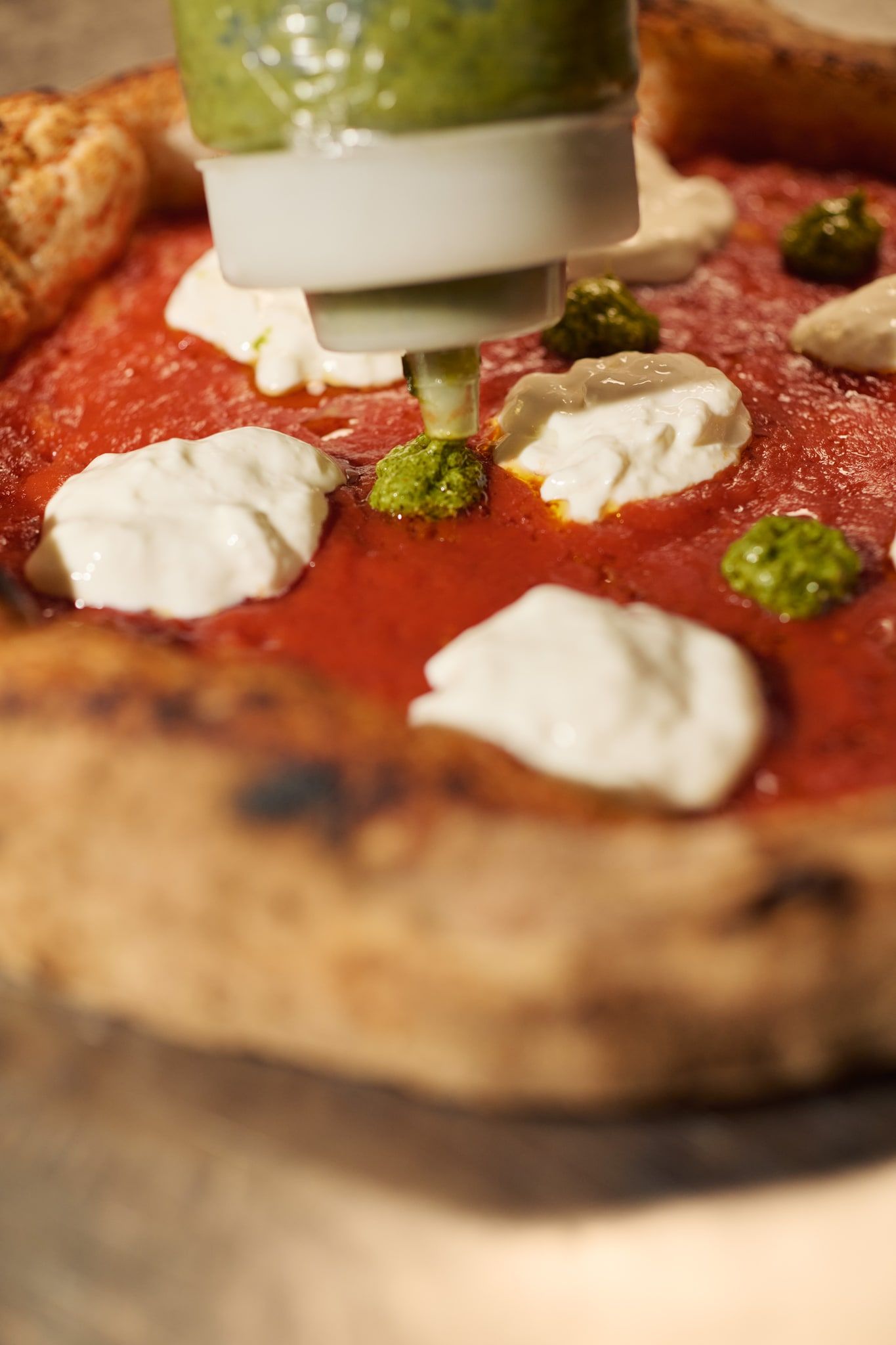 Pesto di basilico sulla stracciatella di una pizza Spaccanapoli, da vicino
